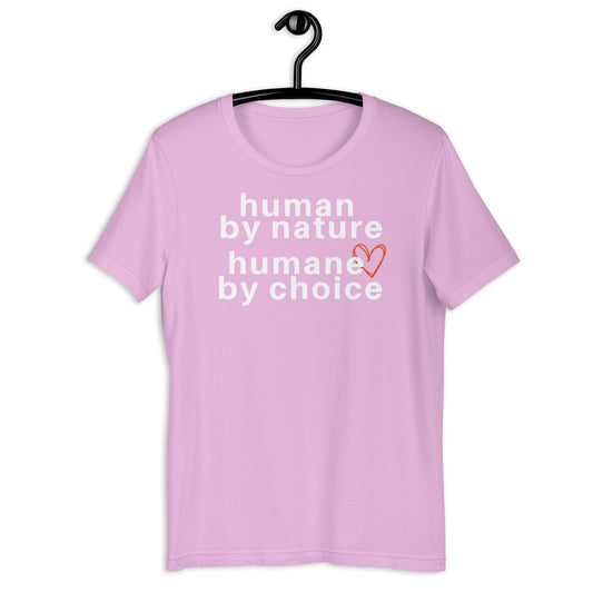 A pink T-shirt with the text 'human by nature humans by choice' printed on it, hanging on a hanger.