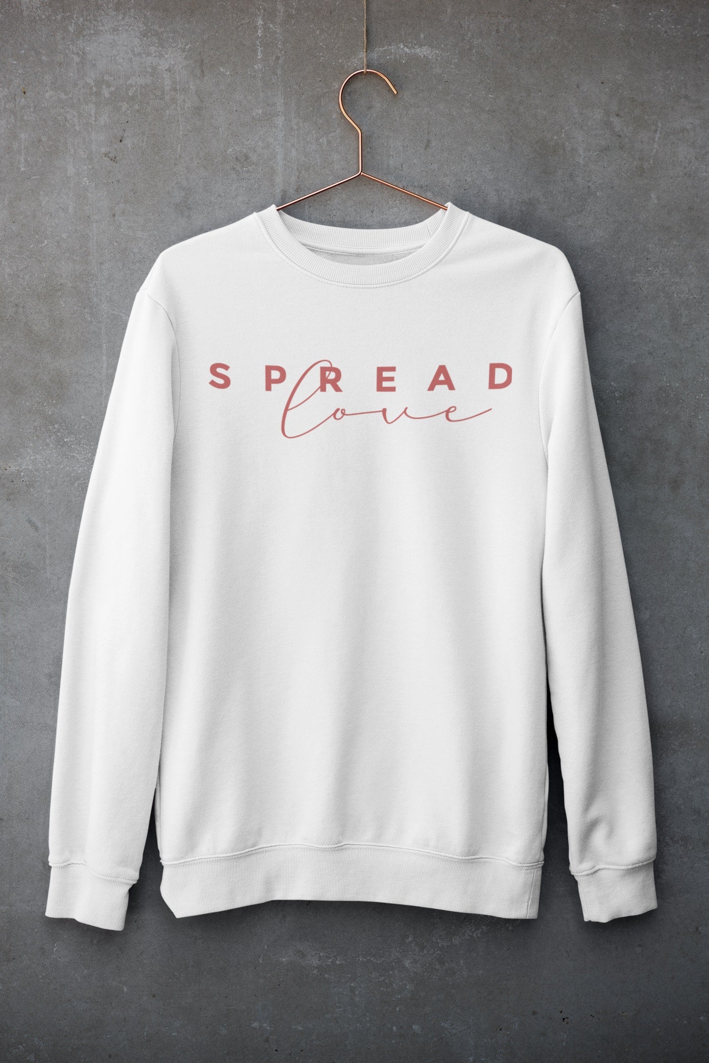 white nelalena spread love sweatshirt hanging against a gray wall