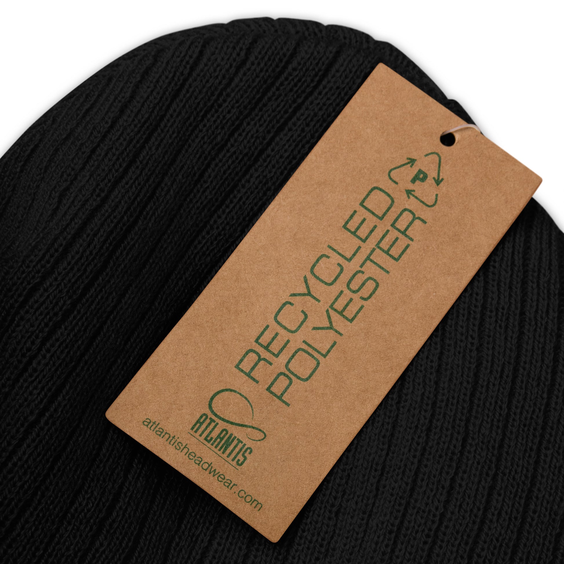 up close image of black  ribbed knit beanie with product details on a brown label 